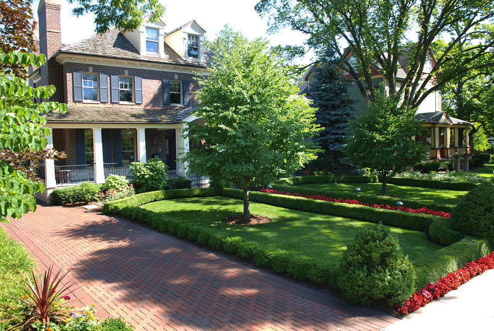 This is an example of a mid-sized traditional backyard partial sun driveway for summer in Chicago with brick pavers.