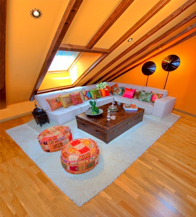 This is an example of a mid-sized eclectic formal enclosed living room in Madrid with orange walls, medium hardwood floors, no fireplace and no tv.