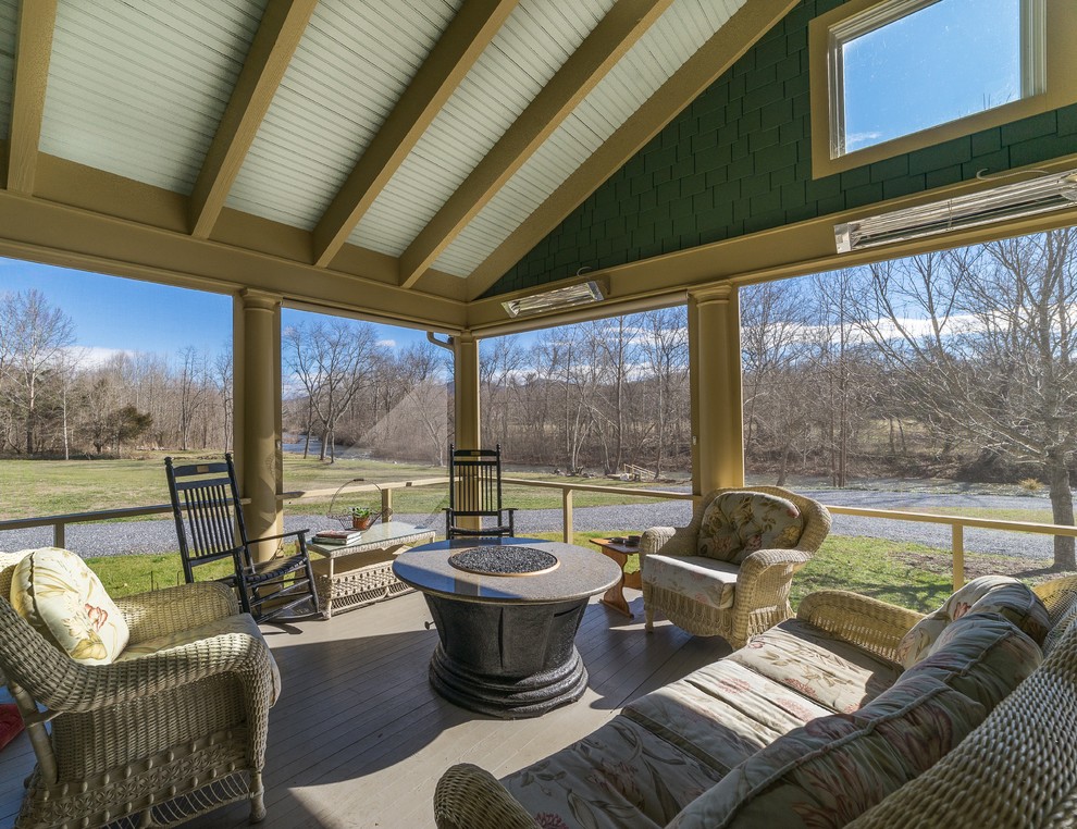 Photo of a large country sunroom in Other with no fireplace and grey floor.