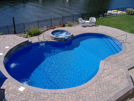Inspiration for a Mid-sized american Backyard Custom-shaped Lap swimming pool in New York With a Hot Tub and Brick Pavers.