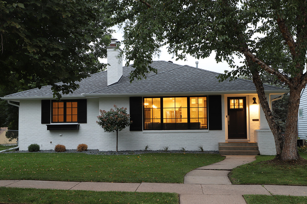 Photo of a mid-sized arts and crafts one-storey brick white house exterior in Minneapolis with a hip roof and a shingle roof.