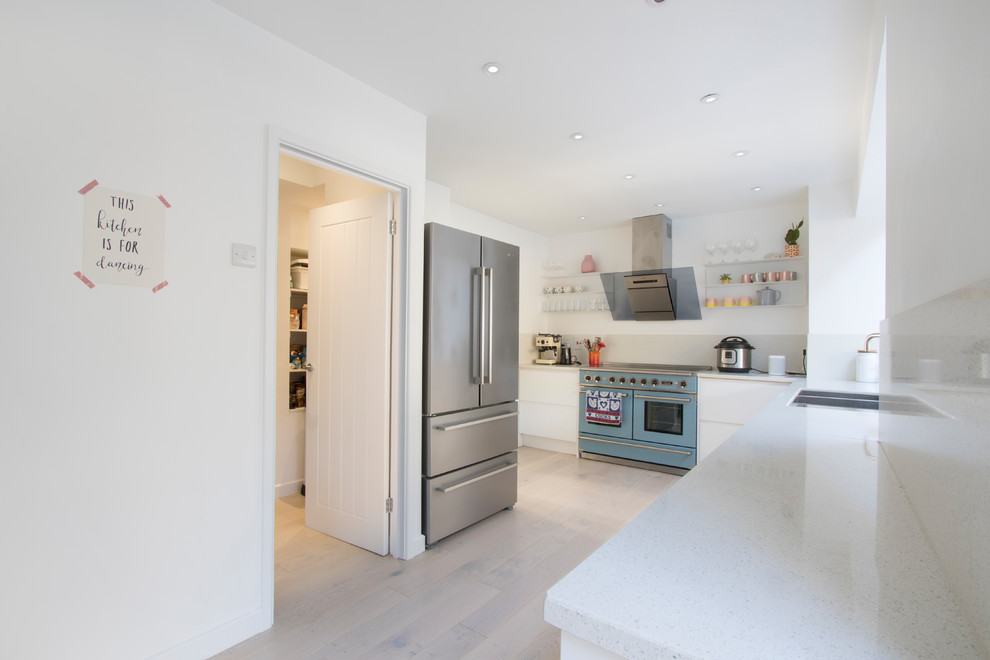 Inspiration for a large modern l-shaped open plan kitchen in Gloucestershire with flat-panel cabinets, white cabinets, solid surface benchtops, beige splashback, no island and beige benchtop.