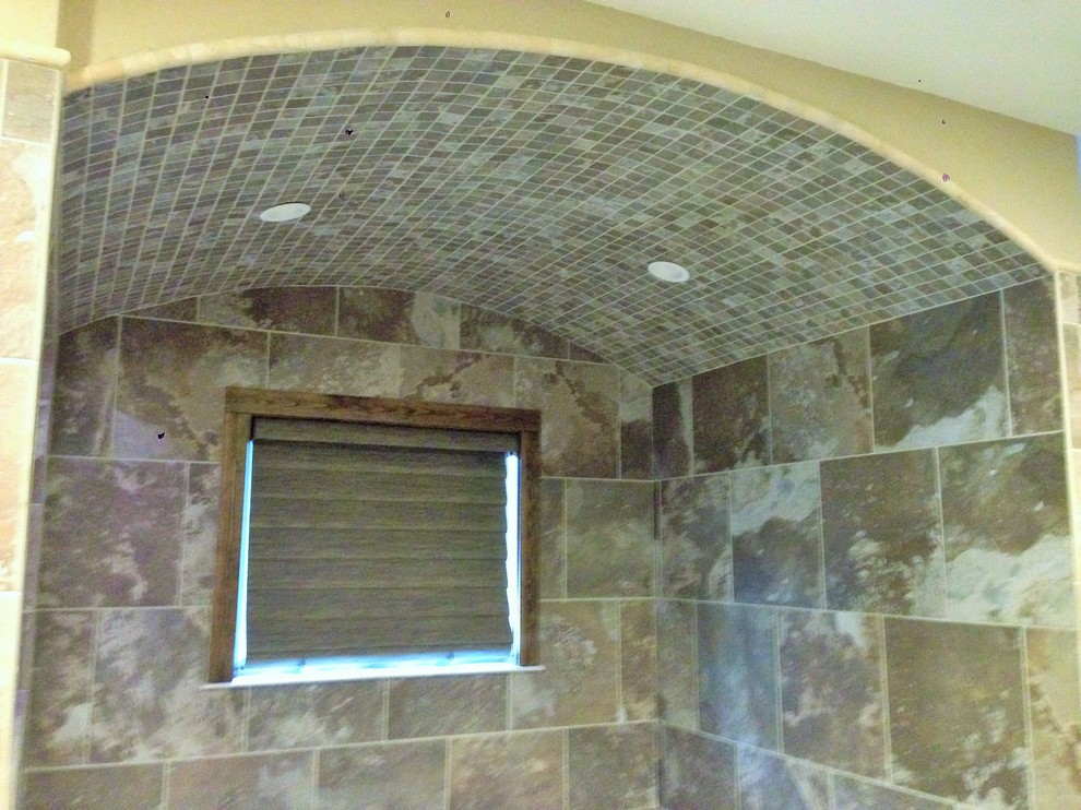 Inspiration for a transitional master multicolored tile and porcelain tile porcelain tile drop-in bathtub remodel with an integrated sink, recessed-panel cabinets, distressed cabinets, solid surface countertops and beige walls