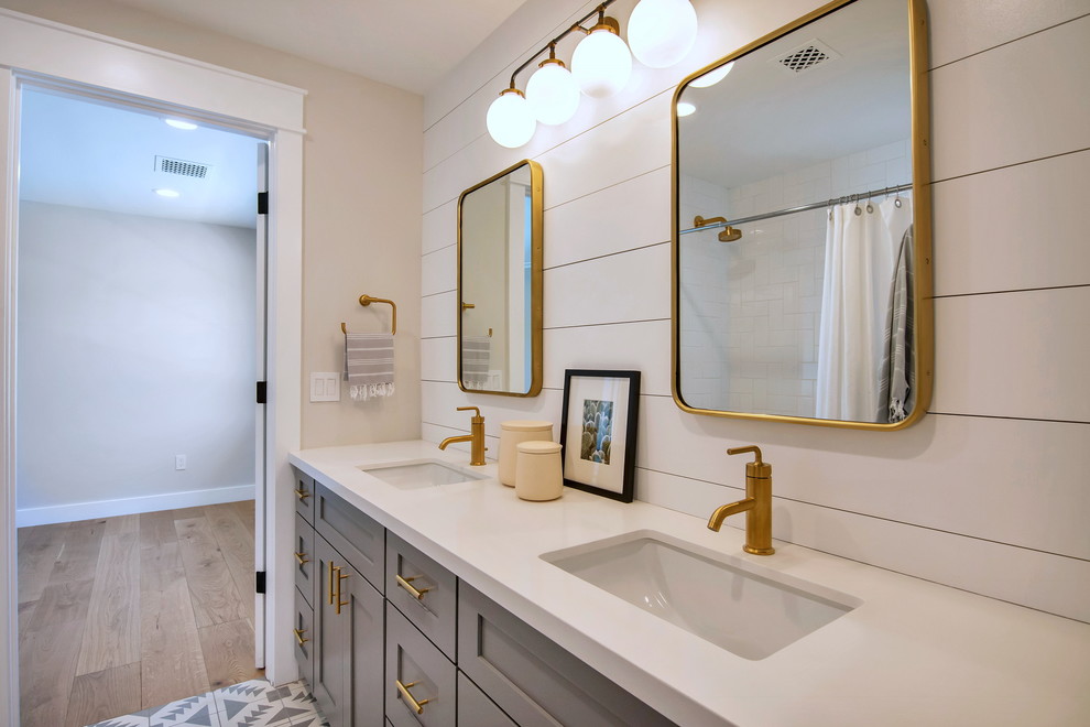 Large arts and crafts kids bathroom in Phoenix with shaker cabinets, grey cabinets, a drop-in tub, a shower/bathtub combo, a one-piece toilet, gray tile, subway tile, grey walls, cement tiles, an undermount sink, marble benchtops, grey floor, an open shower and white benchtops.