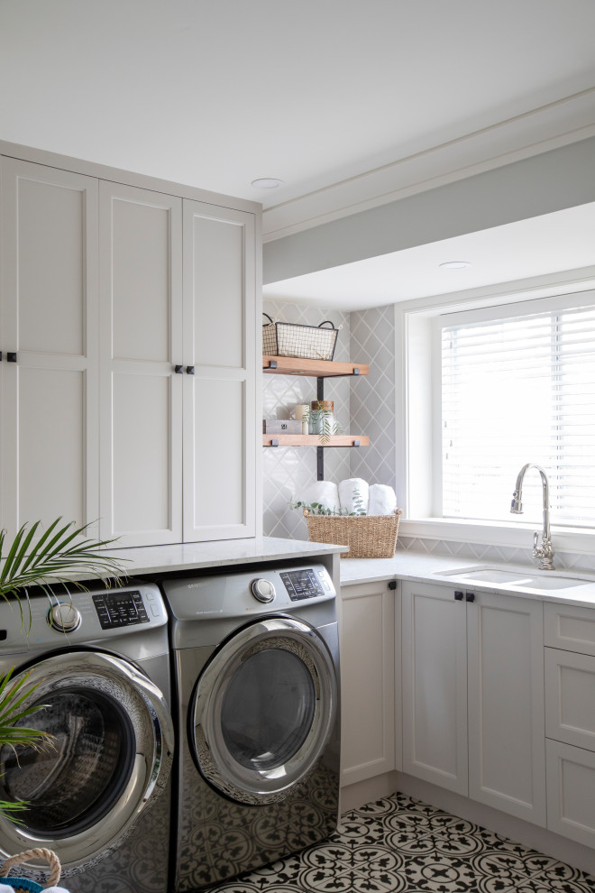 This is an example of a country l-shaped dedicated laundry room in Vancouver with shaker cabinets, white cabinets, white benchtop, a double-bowl sink, a side-by-side washer and dryer and multi-coloured floor.