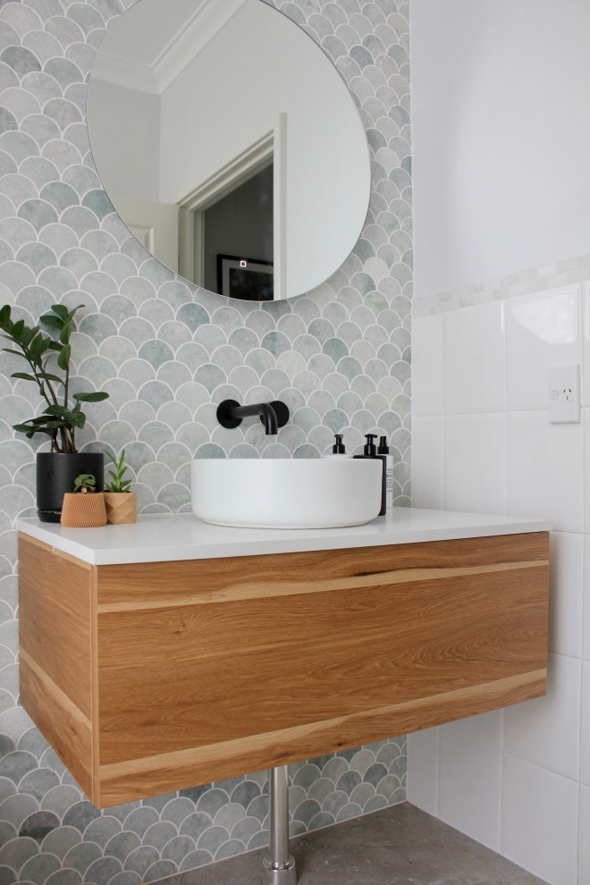 Small midcentury bathroom in Perth with furniture-like cabinets, medium wood cabinets, a two-piece toilet, green tile, marble, green walls, cement tiles, a vessel sink, engineered quartz benchtops, grey floor, a single vanity and a floating vanity.