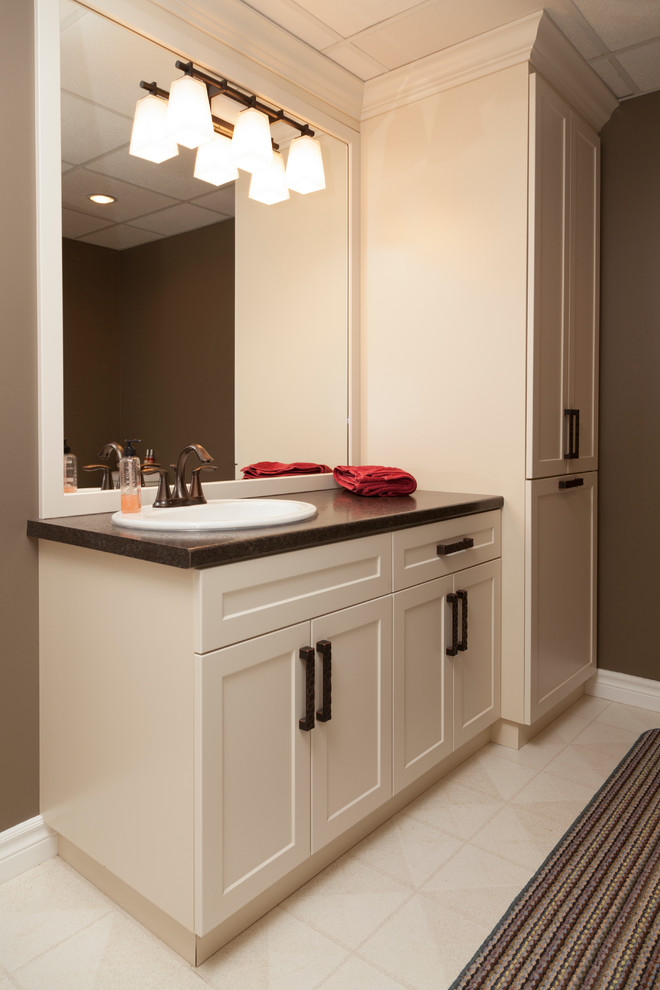 This is an example of a transitional bathroom in Toronto with shaker cabinets, white cabinets, white tile, brown walls, a drop-in sink and engineered quartz benchtops.