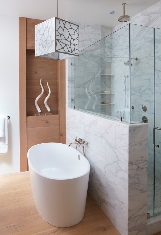 This is an example of a mid-sized contemporary master bathroom in San Francisco with a freestanding tub, gray tile, white tile, white walls, medium hardwood floors, a hinged shower door, flat-panel cabinets, medium wood cabinets, a two-piece toilet, marble, an undermount sink, marble benchtops, brown floor and a corner shower.