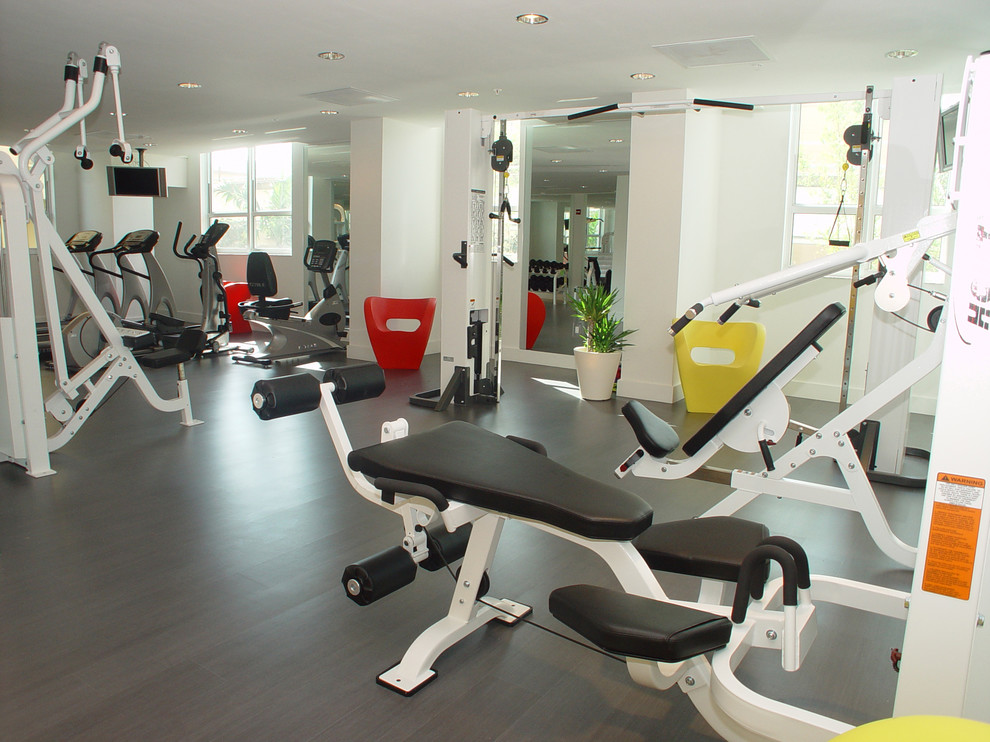 Inspiration for a large contemporary home weight room in Miami with white walls and vinyl floors.