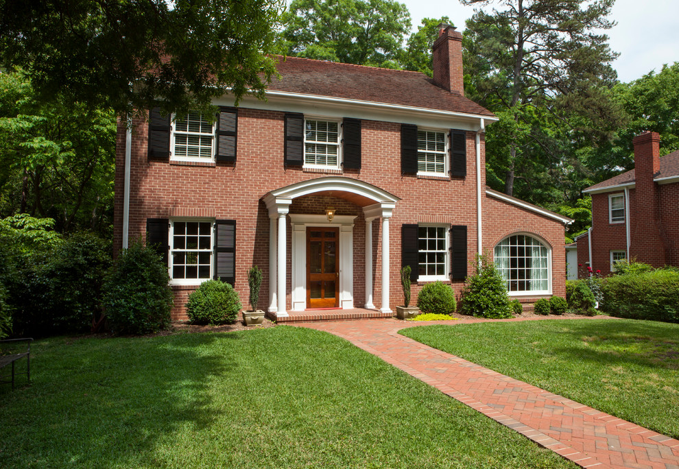 Design ideas for a mid-sized traditional two-storey brick red house exterior in Charlotte.