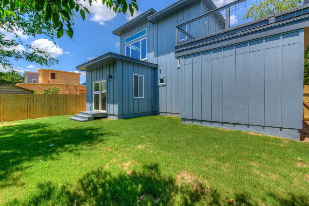 Two-storey blue apartment exterior in Austin with concrete fiberboard siding, a shed roof and a shingle roof.