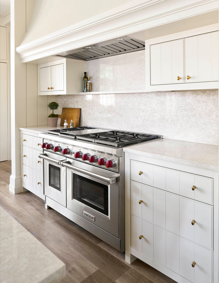 Eat-in kitchen - large transitional u-shaped medium tone wood floor eat-in kitchen idea in Dallas with an undermount sink, flat-panel cabinets, white cabinets, quartz countertops, multicolored backsplash, mosaic tile backsplash, paneled appliances and an island