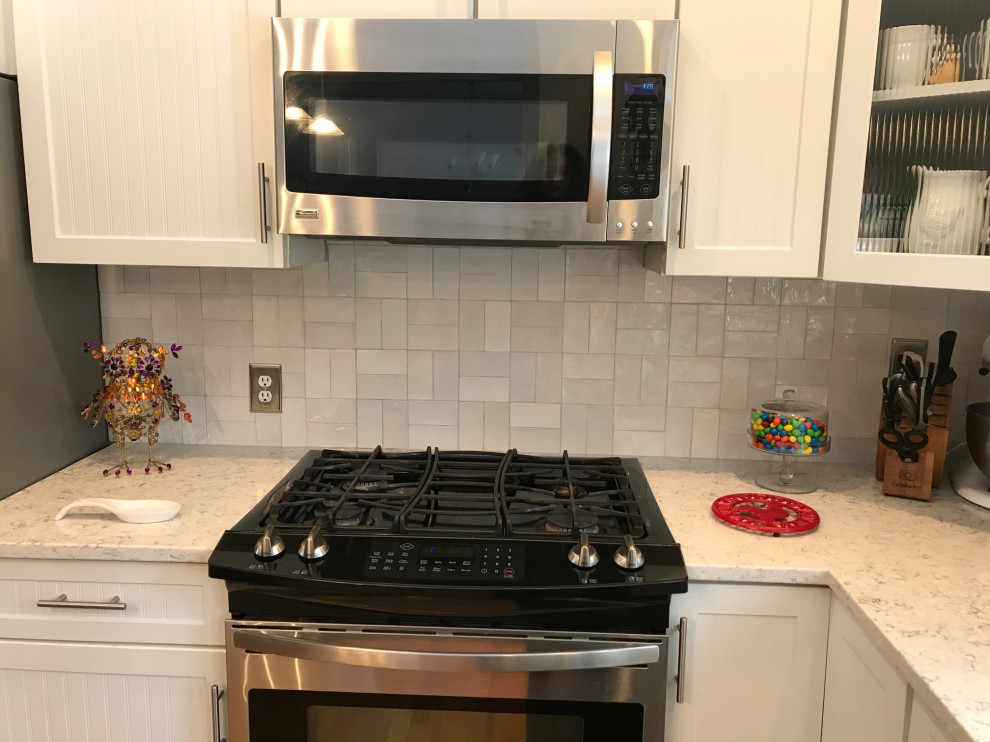 Example of a huge transitional u-shaped eat-in kitchen design with beaded inset cabinets, white cabinets, quartz countertops, white backsplash, ceramic backsplash, stainless steel appliances, an island and white countertops