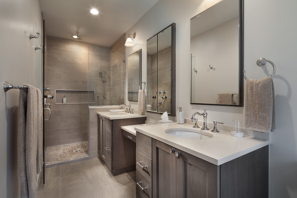 Photo of a mid-sized contemporary master bathroom in DC Metro with shaker cabinets, medium wood cabinets, an alcove shower, beige tile, brown tile, gray tile, porcelain tile, grey walls, porcelain floors, an undermount sink and solid surface benchtops.