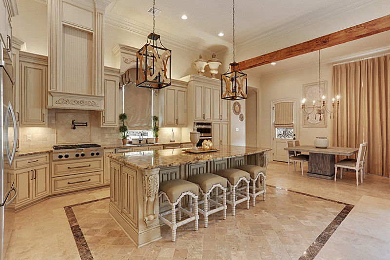 Inspiration for an expansive traditional l-shaped separate kitchen in New Orleans with an undermount sink, raised-panel cabinets, beige cabinets, quartz benchtops, beige splashback, travertine splashback, stainless steel appliances, travertine floors, with island and beige floor.