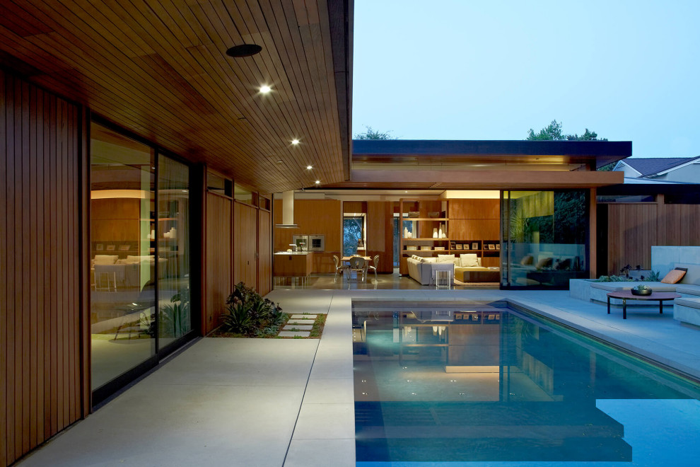 Inspiration for a midcentury rectangular pool with concrete slab.