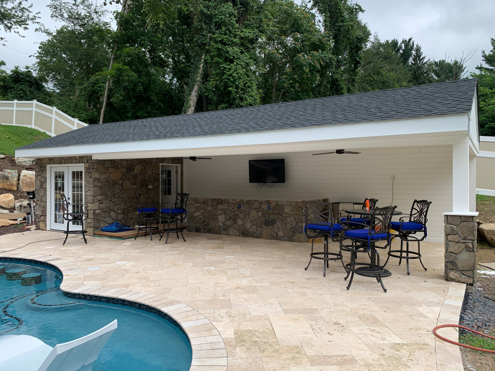 Diseño de casa de la piscina y piscina de tamaño medio tipo riñón en patio trasero con adoquines de piedra natural