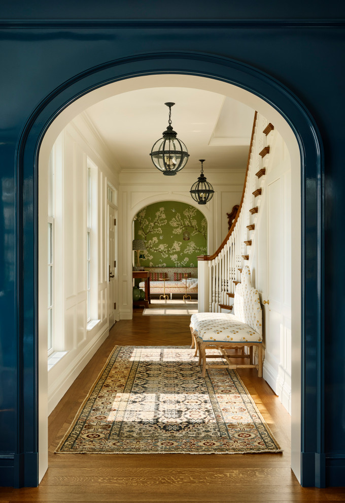 Rye Colonial - Hallway - traditional medium tone wood floor, brown floor and wall paneling hallway idea in New York with white walls