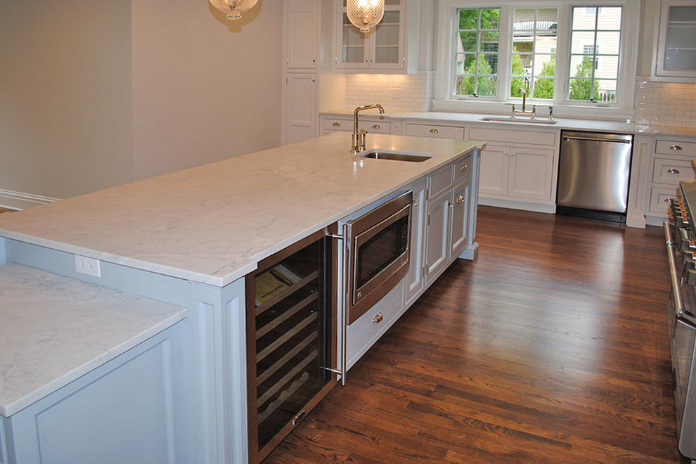 Inspiration for a large transitional l-shaped dark wood floor and brown floor eat-in kitchen remodel with an undermount sink, shaker cabinets, white cabinets, stainless steel appliances and an island
