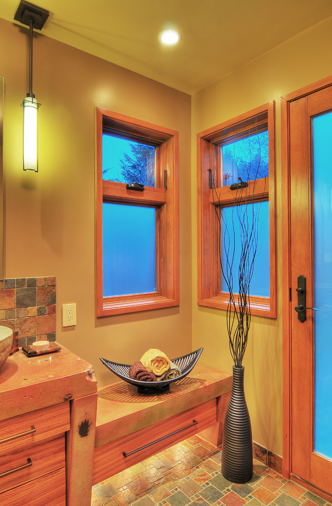 Example of a mid-sized mountain style master multicolored tile and stone tile slate floor doorless shower design in Seattle with a vessel sink, flat-panel cabinets, medium tone wood cabinets, concrete countertops, a two-piece toilet and green walls
