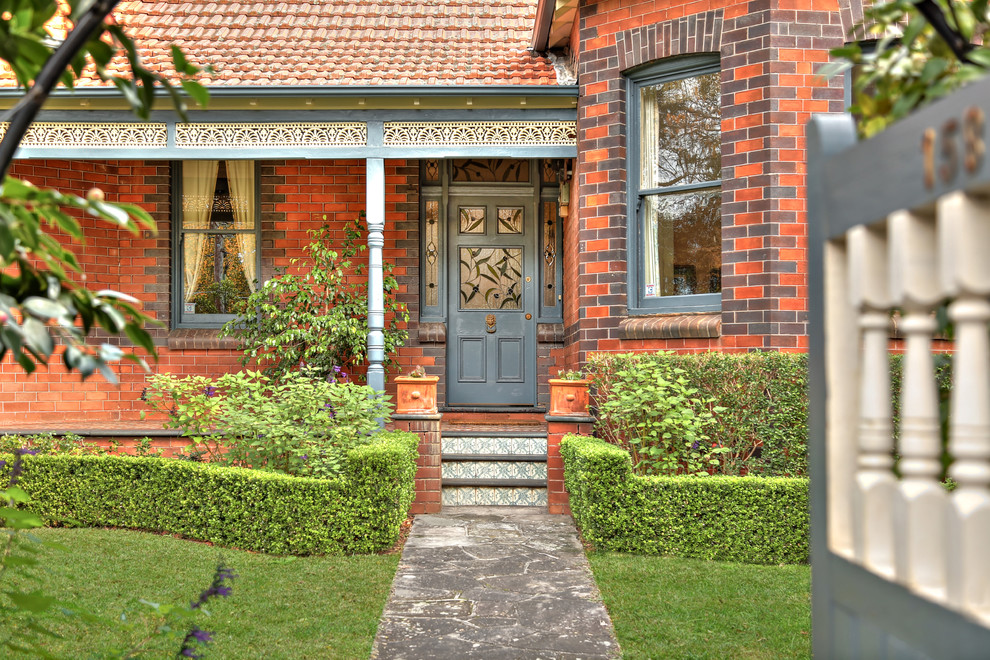 Design ideas for a large traditional front door in Sydney with brick floors, a single front door, a blue front door, red walls and red floor.