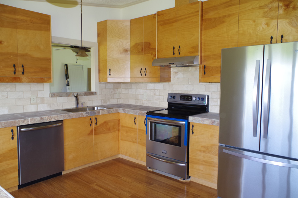 Aménagement d'une cuisine américaine contemporaine en L et bois clair de taille moyenne avec un placard à porte plane, plan de travail carrelé, îlot et un plan de travail gris.