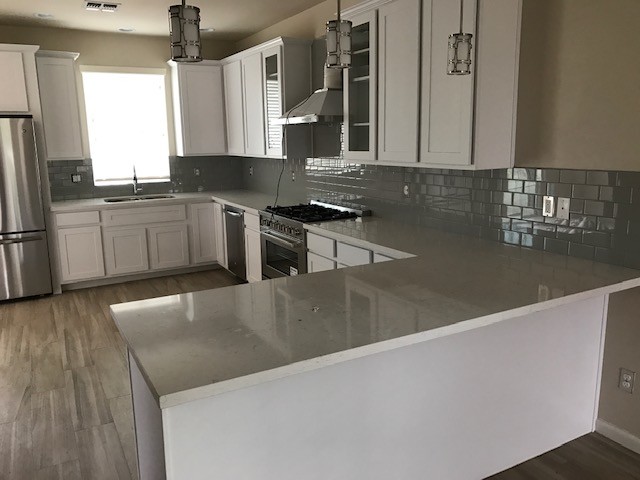 Inspiration for a mid-sized transitional u-shaped porcelain tile and gray floor eat-in kitchen remodel in Phoenix with a drop-in sink, recessed-panel cabinets, white cabinets, quartzite countertops, gray backsplash, subway tile backsplash, stainless steel appliances, a peninsula and white countertops