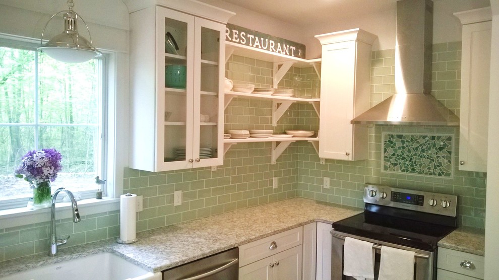 Mid-sized beach style l-shaped eat-in kitchen in Grand Rapids with a farmhouse sink, shaker cabinets, white cabinets, quartzite benchtops, green splashback, glass tile splashback, stainless steel appliances and light hardwood floors.