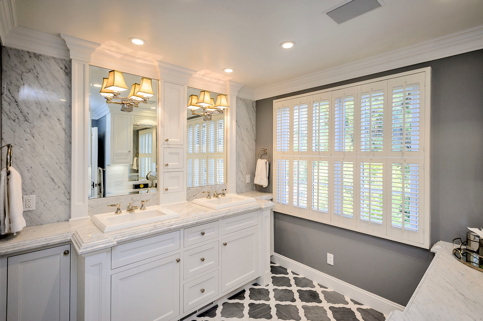 Large traditional master bathroom in San Francisco with a drop-in sink, recessed-panel cabinets, white cabinets, white tile, gray tile, grey walls, marble benchtops, grey floor and grey benchtops.