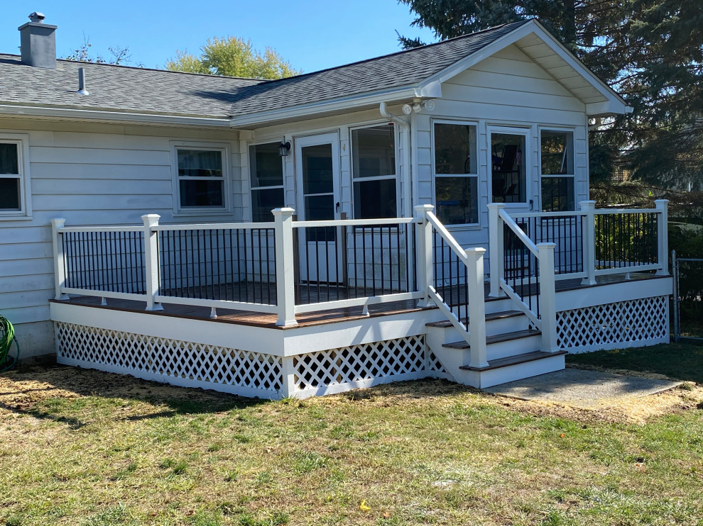 This is an example of a mid-sized traditional backyard and ground level deck in New York with with skirting, no cover and mixed railing.