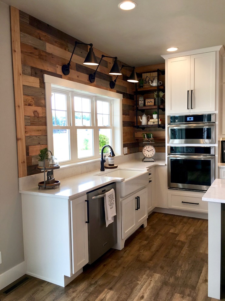 Design ideas for a mid-sized country u-shaped eat-in kitchen in Other with a farmhouse sink, shaker cabinets, white cabinets, marble benchtops, white splashback, subway tile splashback, stainless steel appliances, vinyl floors, with island and brown floor.
