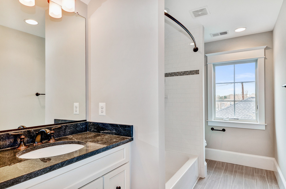 Example of a mid-sized transitional kids' white tile and ceramic tile ceramic tile and brown floor drop-in bathtub design in DC Metro with a one-piece toilet, gray walls, an undermount sink, shaker cabinets, white cabinets and marble countertops