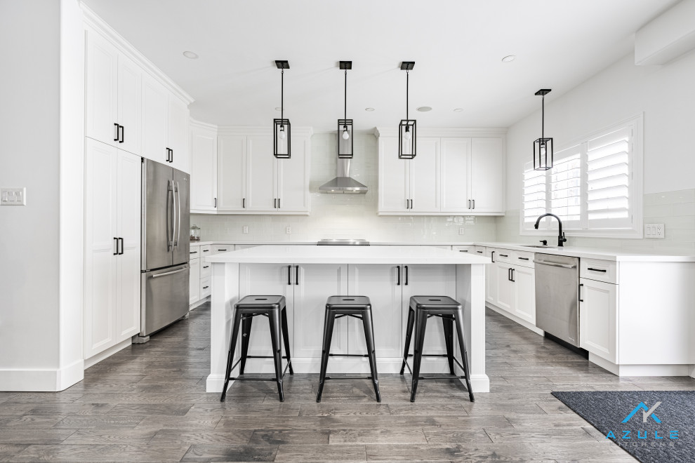 Large transitional u-shaped eat-in kitchen photo with recessed-panel cabinets, white cabinets, quartz countertops, white backsplash, cement tile backsplash, an island and white countertops