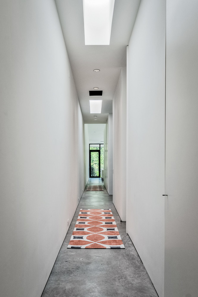 Photo of a modern hallway in Dallas with white walls and concrete floors.