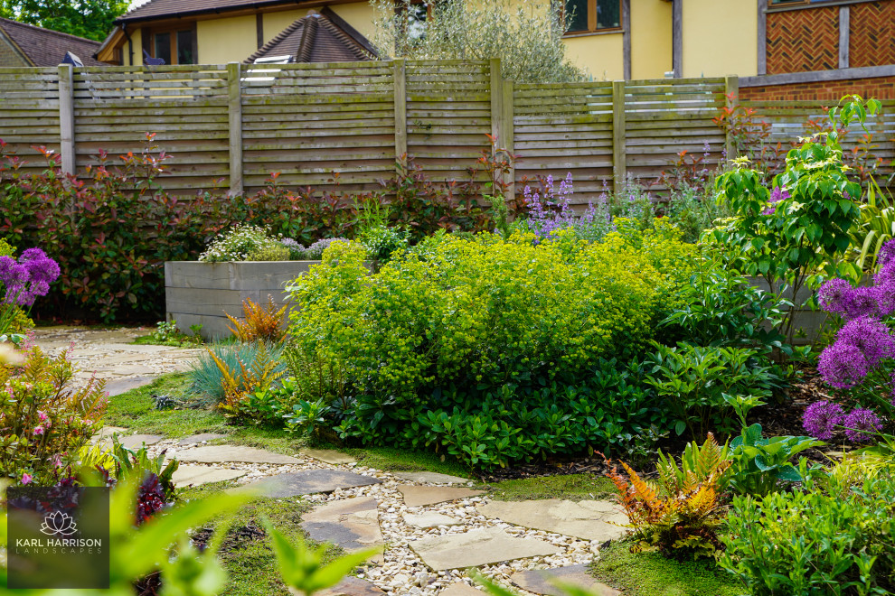 Inspiration pour un jardin arrière nordique de taille moyenne et l'été avec une exposition ensoleillée, une terrasse en bois et une clôture en bois.
