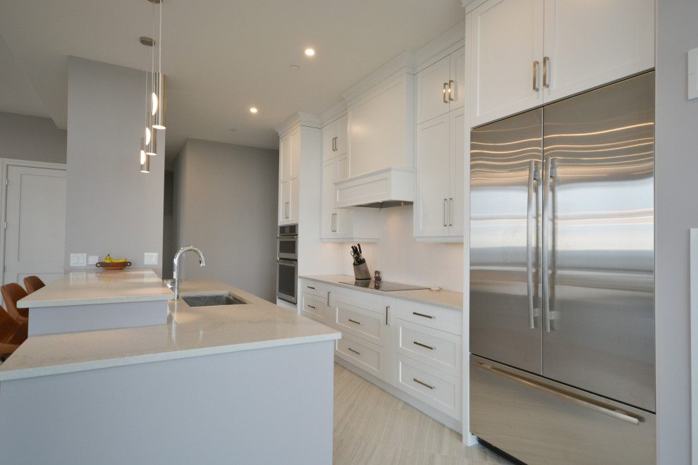 Mid-sized transitional open concept kitchen photo in Toronto with shaker cabinets, white cabinets, quartz countertops, stainless steel appliances, a peninsula and white countertops