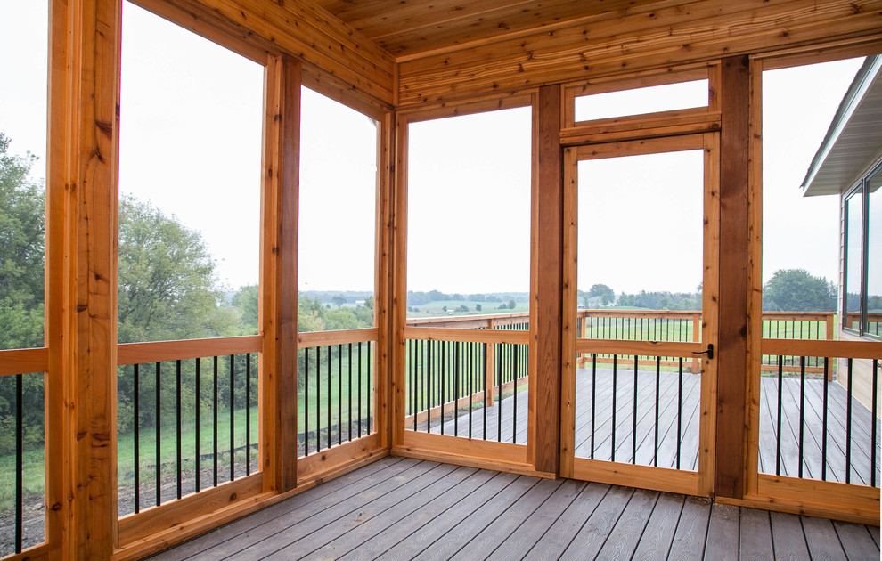 Example of a transitional backyard deck design in Minneapolis with a fire pit and a roof extension