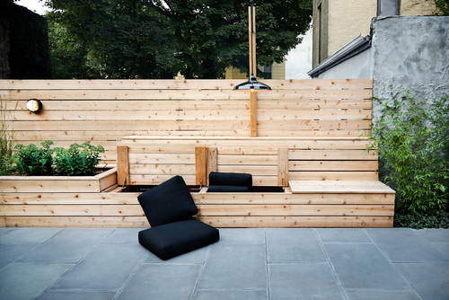 There is a multi-use feature in this yard. It is part bench, part storage, and part raised garden bed. This is a great structure that brings a number of differing elements to the yard space.