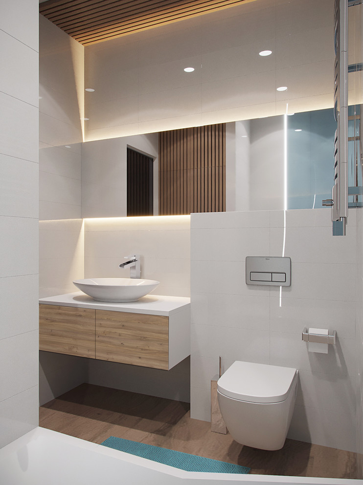 Design ideas for a small contemporary bathroom in Valencia with flat-panel cabinets, a wall-mount toilet, white tile, ceramic tile, white walls, porcelain floors, solid surface benchtops, brown floor, white benchtops, light wood cabinets and a vessel sink.