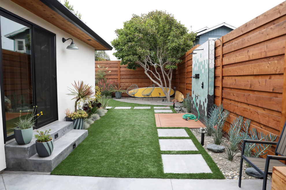Идея дизайна: солнечный, летний засухоустойчивый сад среднего размера на боковом дворе в стиле модернизм с газонным бордюром, хорошей освещенностью, мощением тротуарной плиткой и с металлическим забором