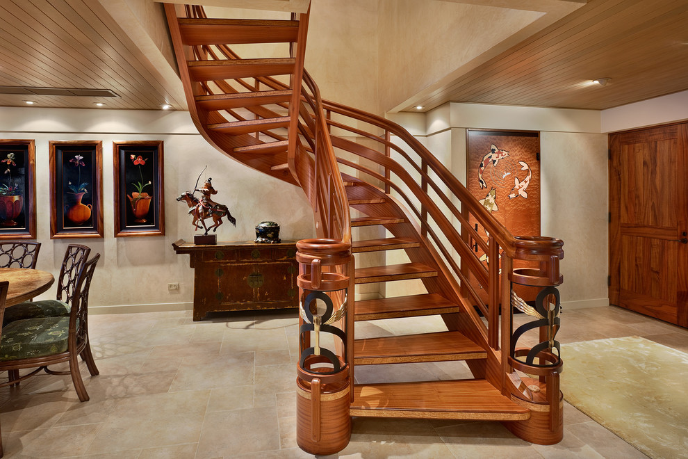 Design ideas for a mid-sized tropical wood curved staircase in Hawaii with open risers and wood railing.