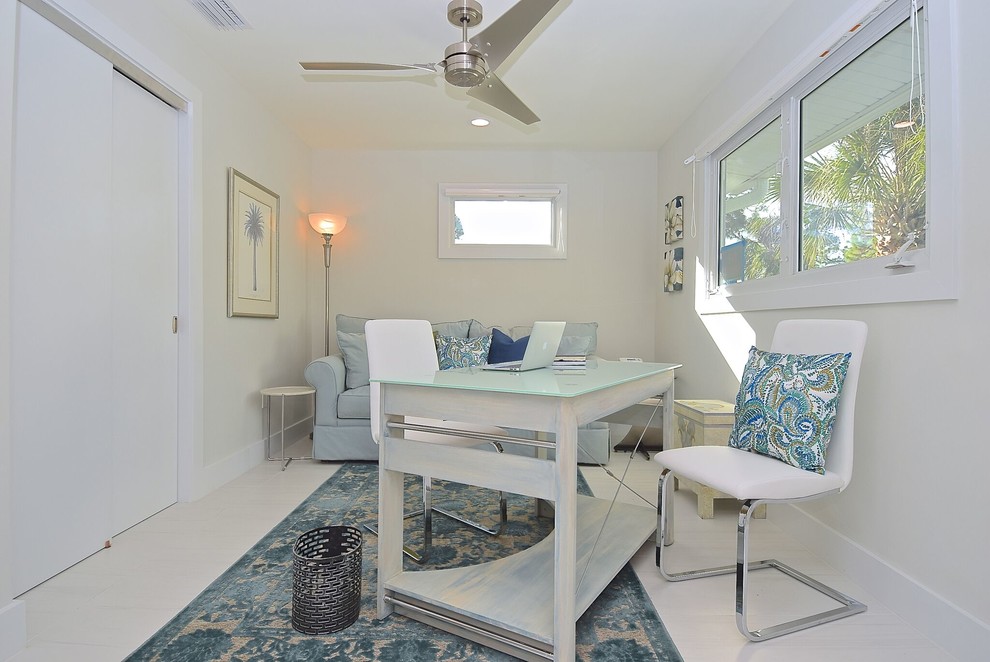 Photo of a mid-sized beach style home studio in Tampa with white walls, laminate floors, no fireplace, a freestanding desk and white floor.