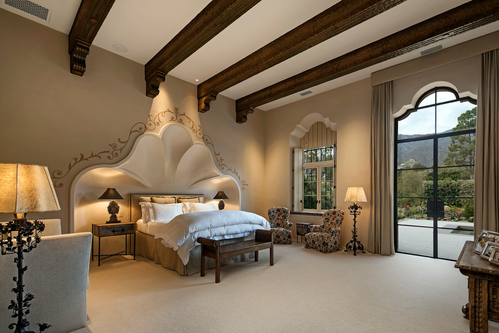 This is an example of a large mediterranean master bedroom in Santa Barbara with beige walls, carpet and no fireplace.