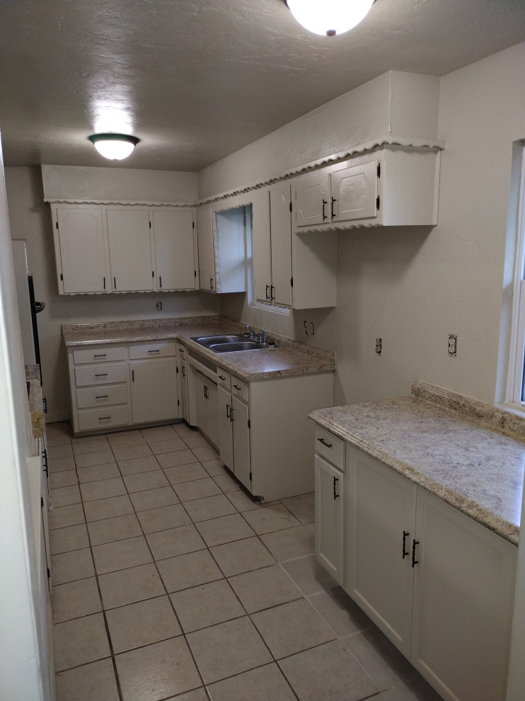 Photo of an expansive modern laundry room in Oklahoma City with a double-bowl sink, laminate benchtops, beige walls, vinyl floors, a side-by-side washer and dryer, grey floor and beige benchtop.