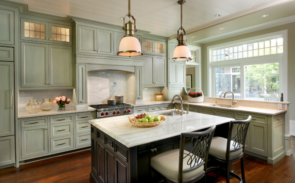 Example of a classic dark wood floor kitchen design in Chicago with an undermount sink, recessed-panel cabinets, green cabinets, white backsplash and paneled appliances