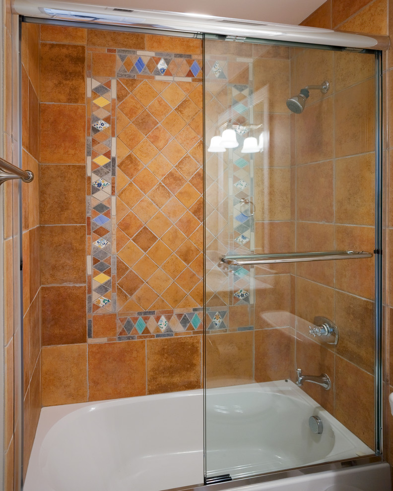 This is an example of a traditional kids bathroom in DC Metro with a drop-in tub, a shower/bathtub combo, brown tile and porcelain tile.