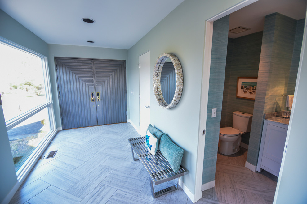 This is an example of a large beach style front door in Baltimore with blue walls, porcelain floors, a double front door, a gray front door and grey floor.
