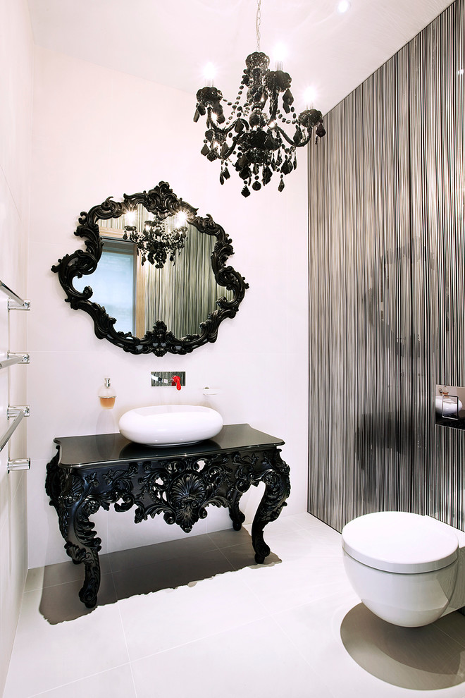 This is an example of a contemporary powder room in London with a vessel sink, furniture-like cabinets, black cabinets, a wall-mount toilet and multi-coloured walls.