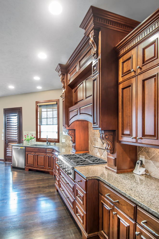 Eat-in kitchen - dark wood floor eat-in kitchen idea with an undermount sink, medium tone wood cabinets, granite countertops, beige backsplash, ceramic backsplash, stainless steel appliances and an island