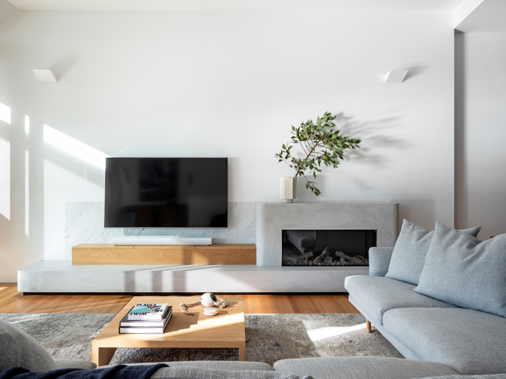 This is an example of a contemporary living room in Sydney with white walls, a ribbon fireplace and a wall-mounted tv.